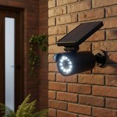 Solar-powered outdoor security light attached to a brick wall